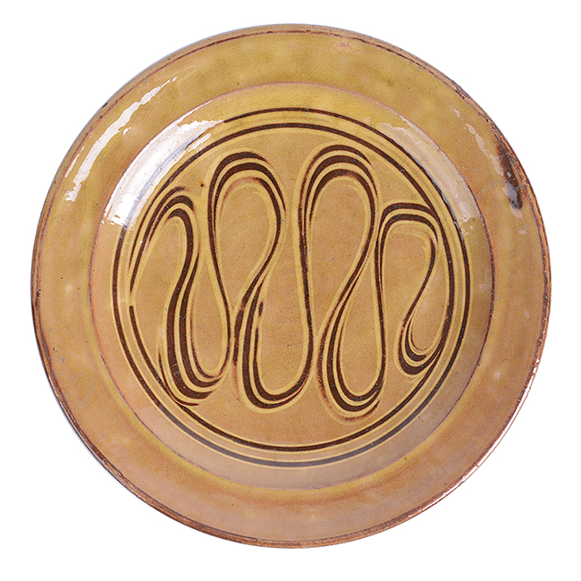 An amber earthenware dish made by Michael Cardew in circa 1932 sold at auction by Maak Contemporary Ceramics