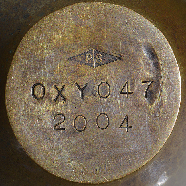 An impressed maker's mark on a copper and white metal vessel made by Pete Stevens